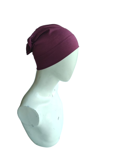 Purple headscarf on a mannequin head against a white background